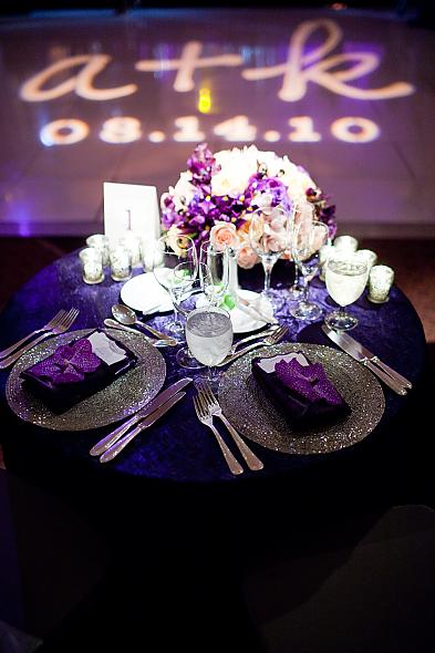 Purple wedding reception decor with chandeliers and purple orchids